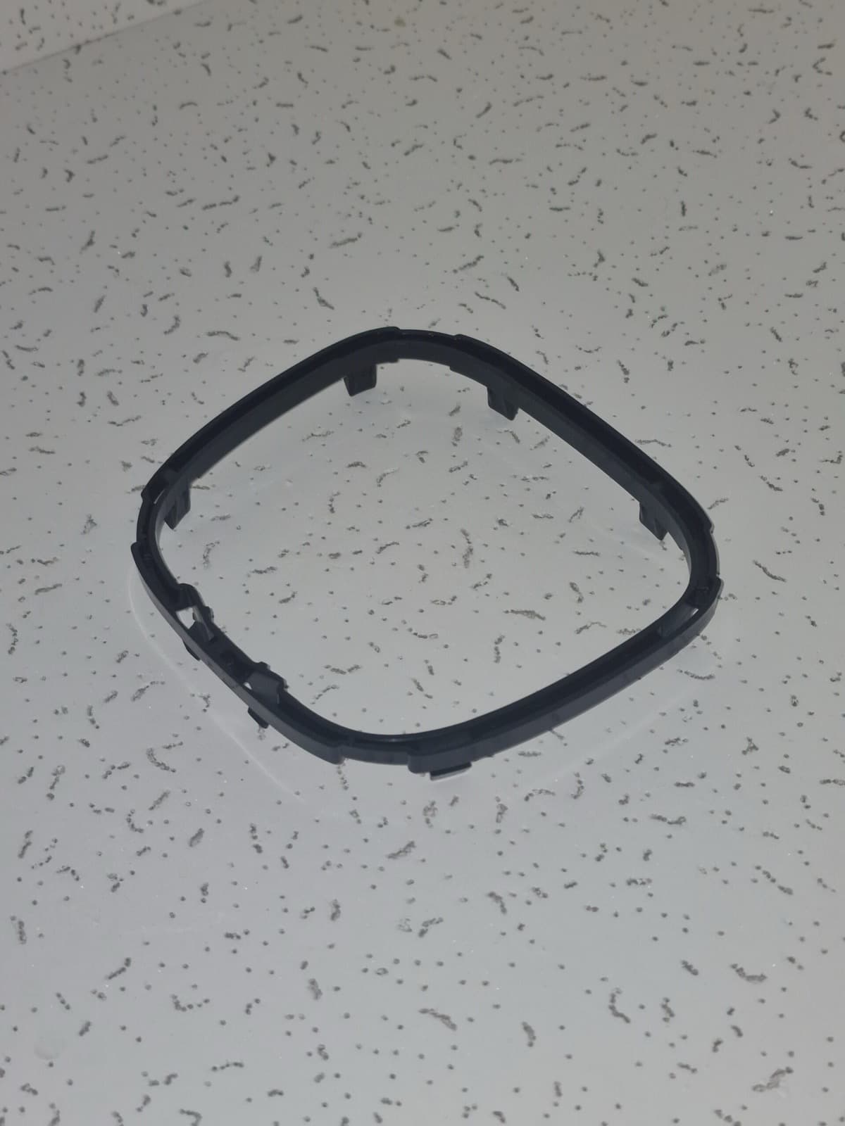 Cornice nera arrotondata con dentini di aggancio lungo il perimetro.