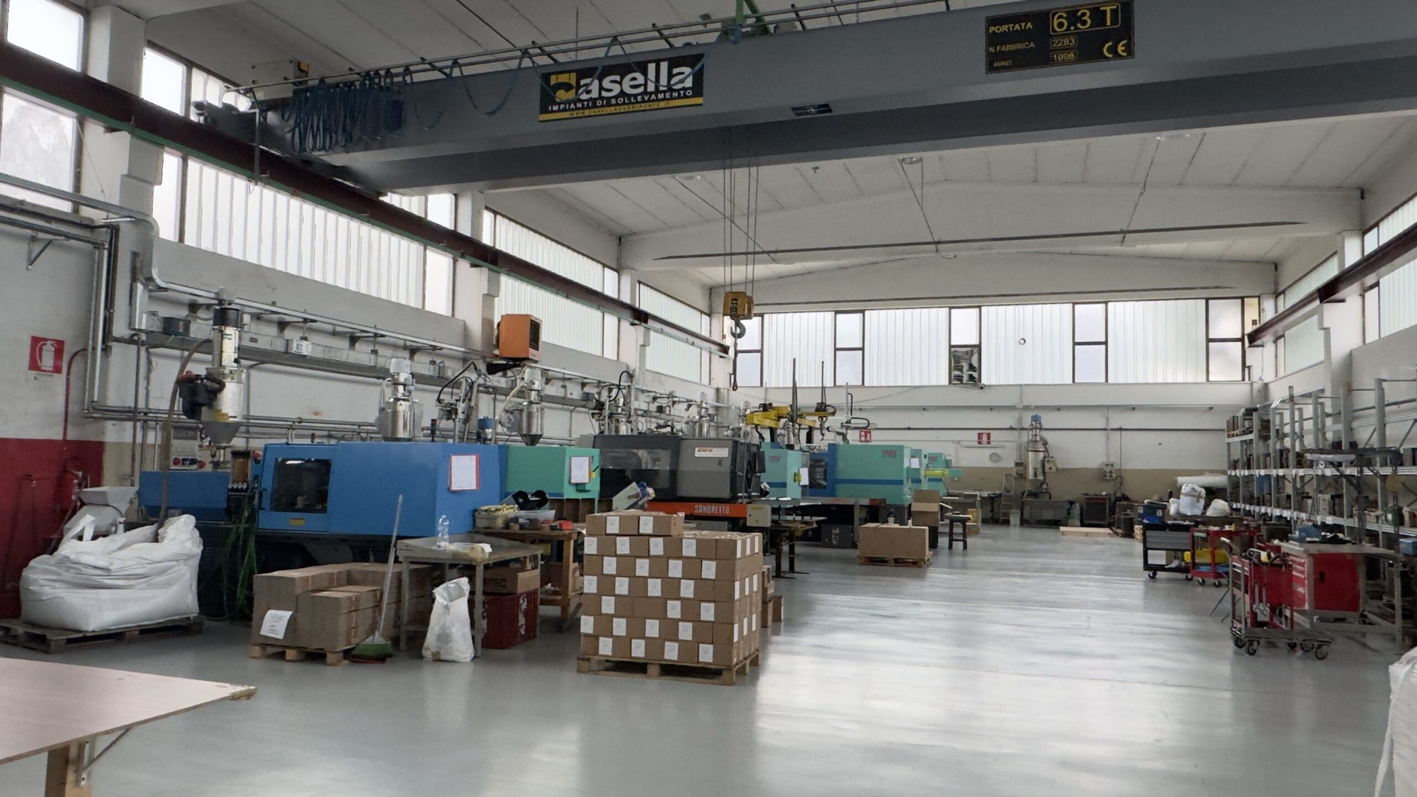 Interno dello stabilimento PlastMotik a Torino, con le presse allineate sotto il carroponte.